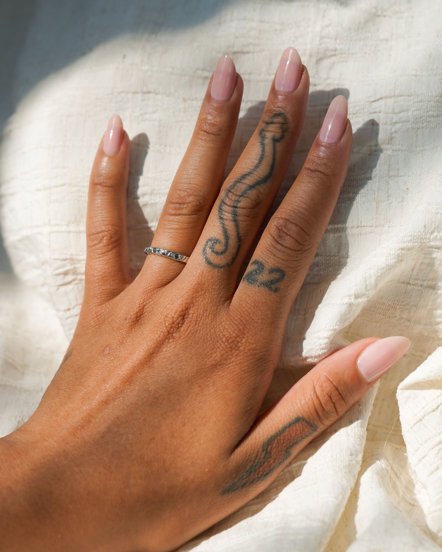 Blue Sapphire Willow Band set in 14k white gold modeled on a hand