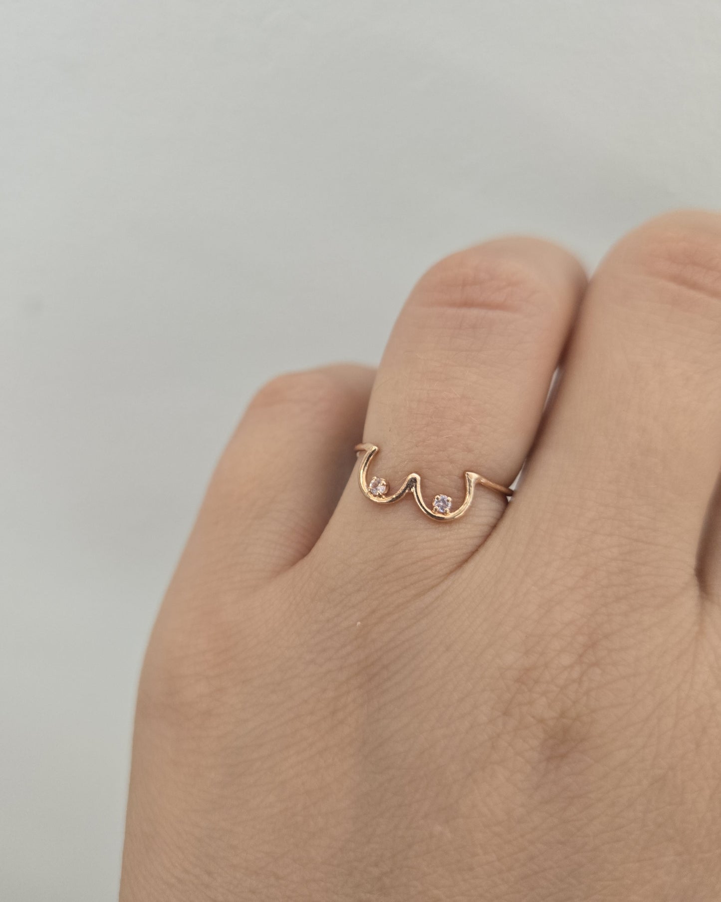 Pastel Pink Sapphire Boob Ring modeled on a hand