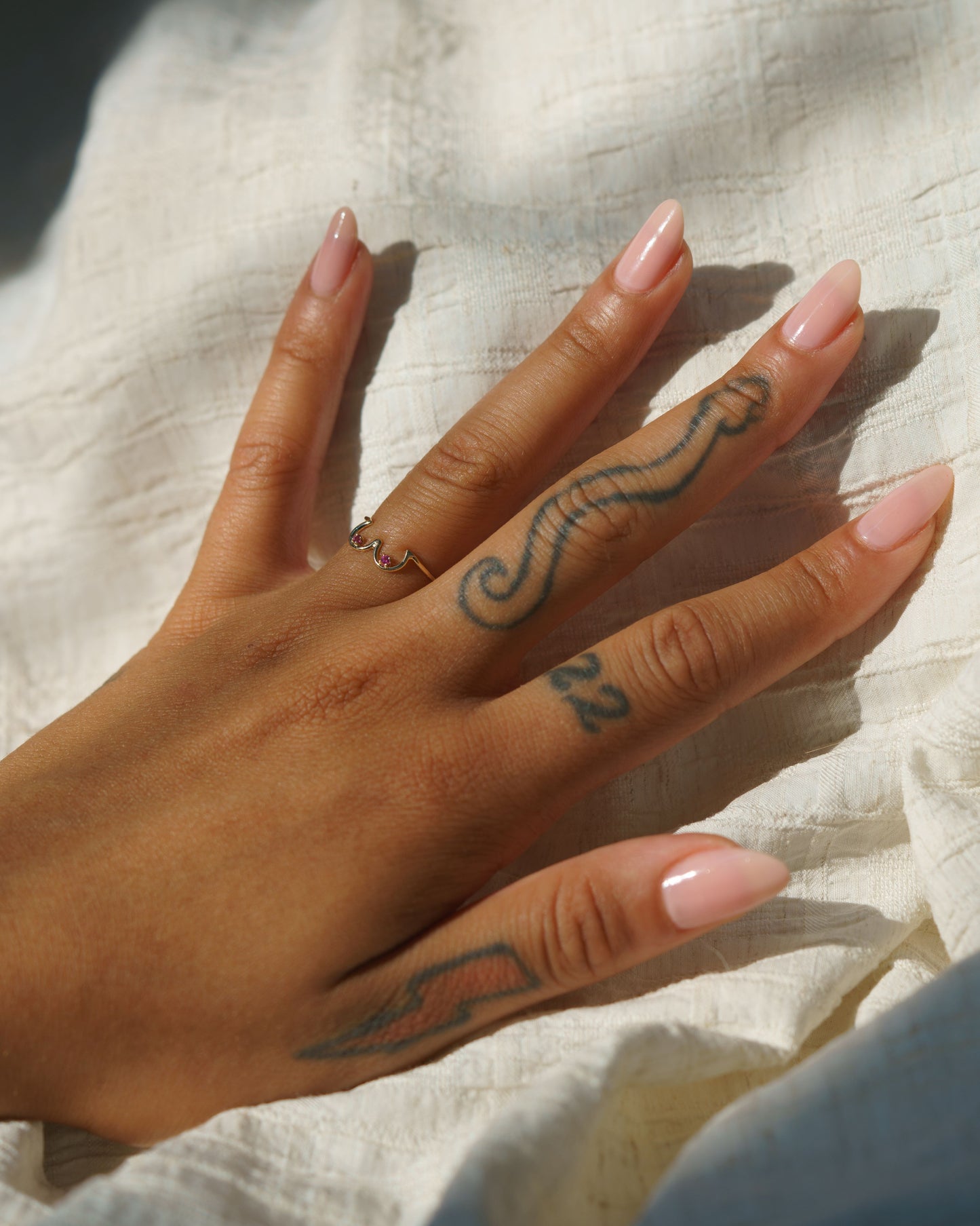 Pink Sapphire Boob Ring in 14k yellow gold modeled on a hand