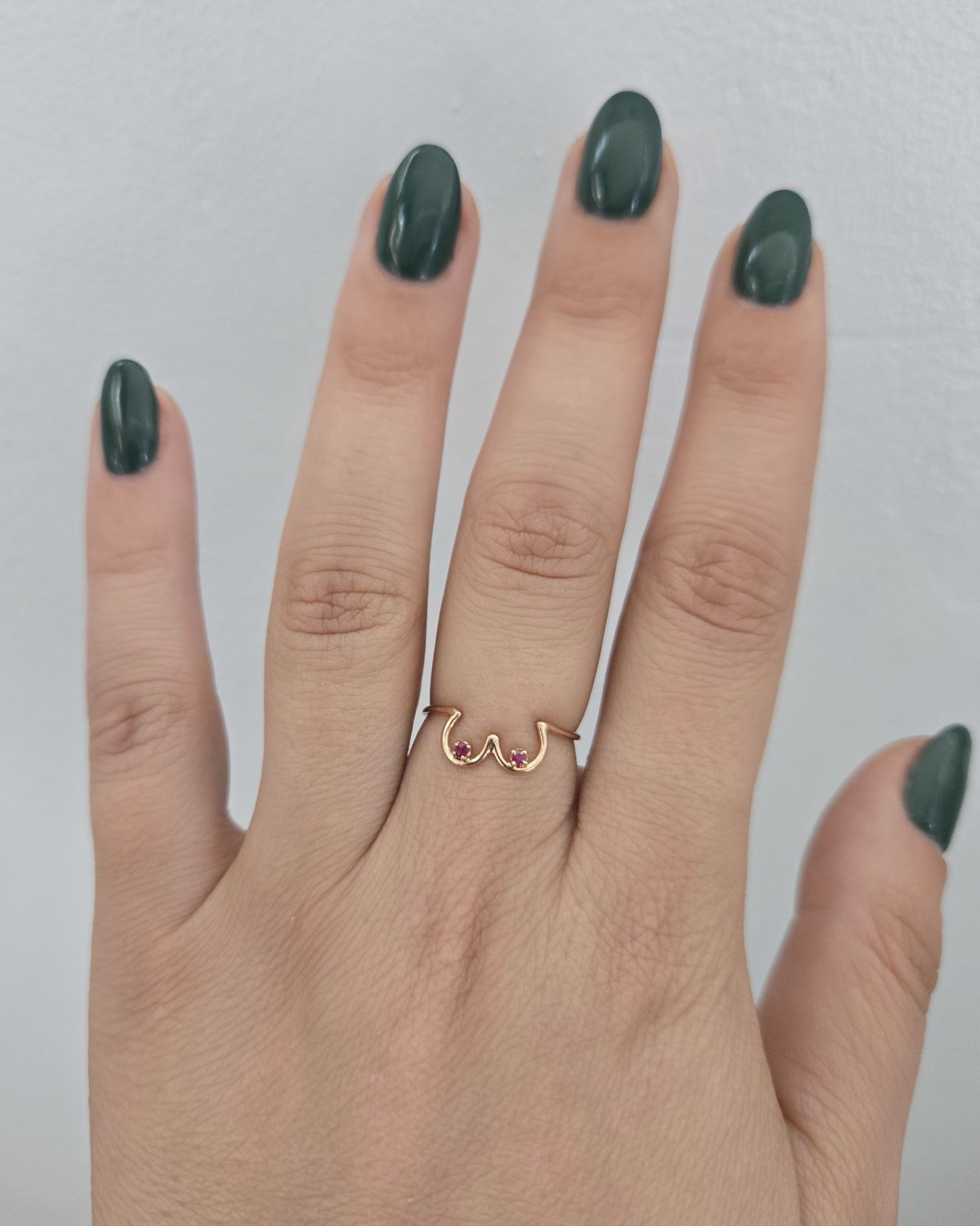 Ruby Boob Ring in rose gold modeled on a hand