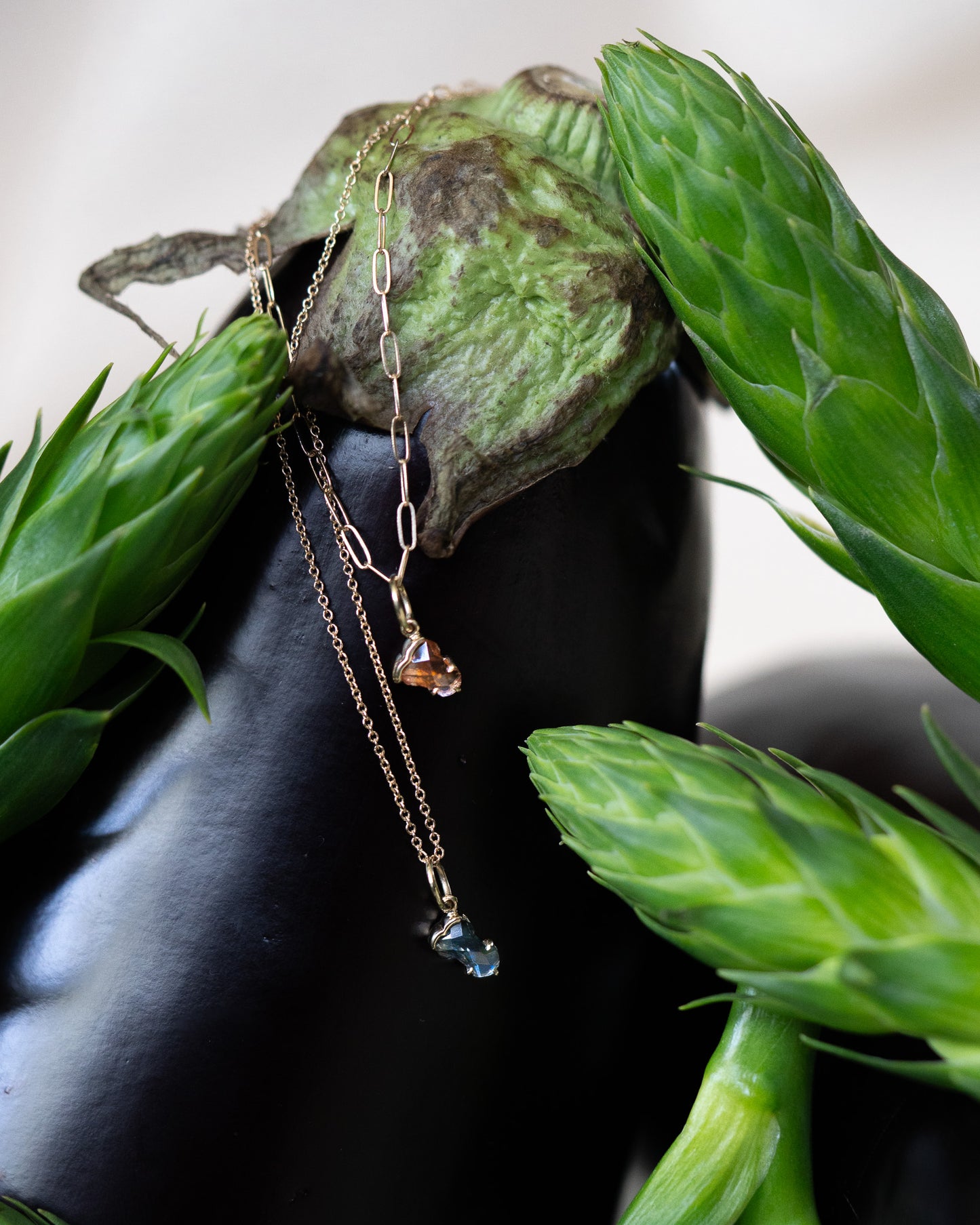 Hermes charms hanging from an eggplant with flowers