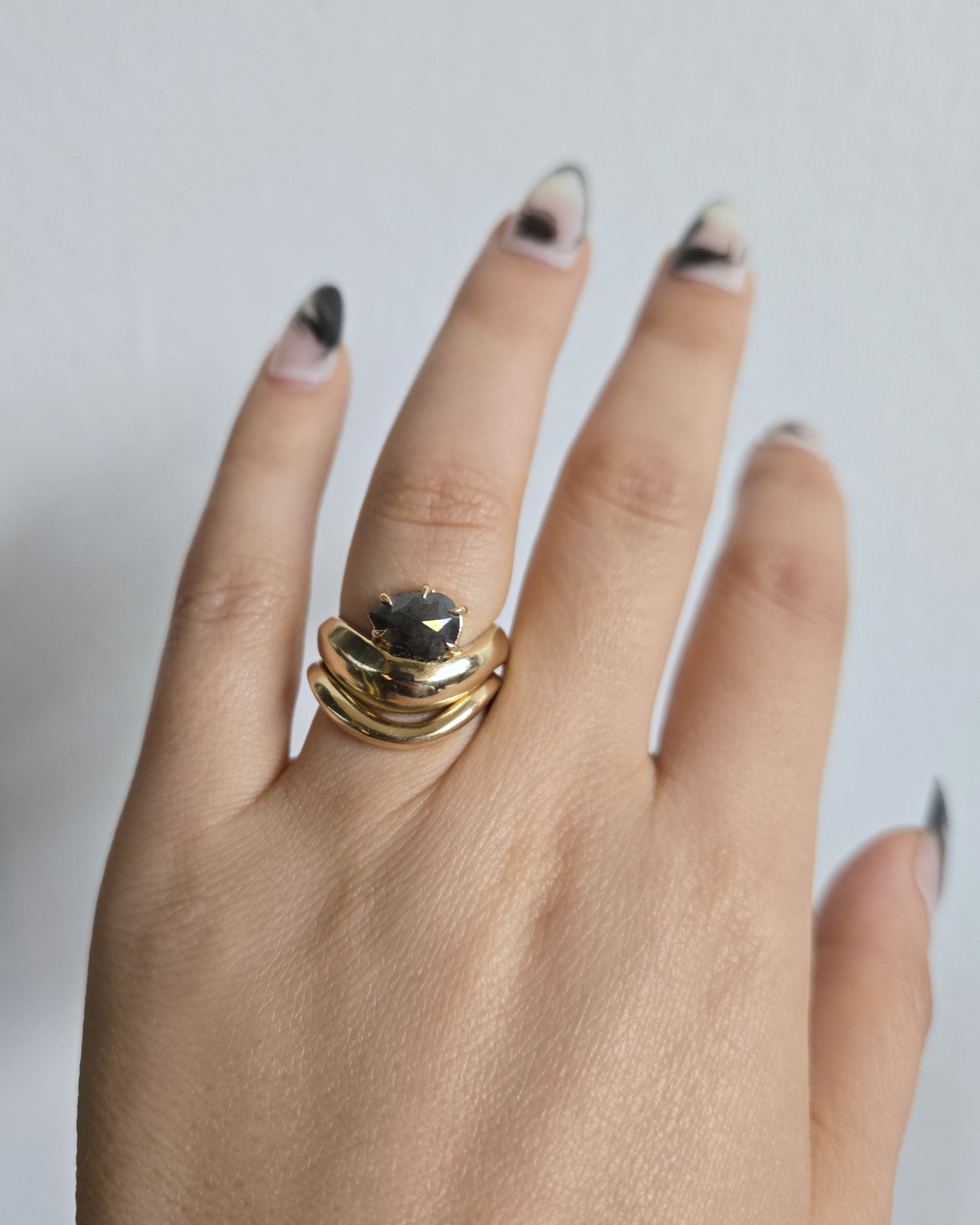 Hand carved and curved Cantafel Band in 14k yellow gold stacked with Maevyth Solitaire