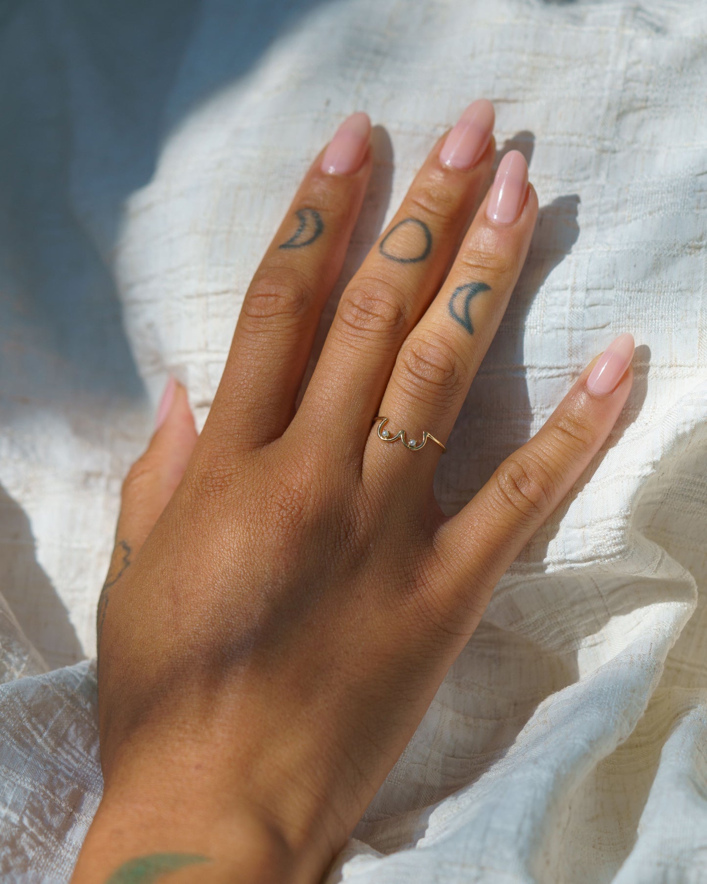 Pearl Boob Ring set in 14k yellow gold modeled on a hand